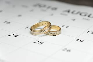 Casarse civil rápido: alianzas de boda en oro amarillo encima de un calendario