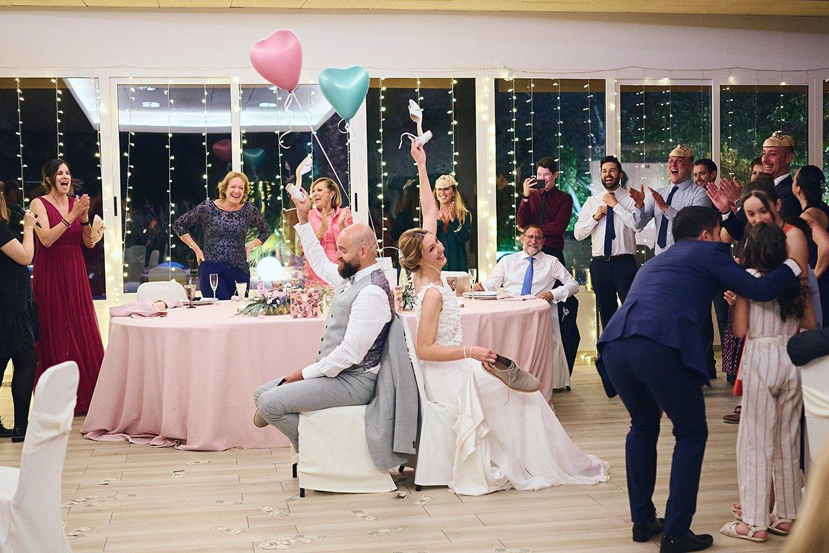 Preguntas para parejas juego: pareja de recién casados sentados espalda contra espalda mientras contestan las preguntas para parejas juego del zapato