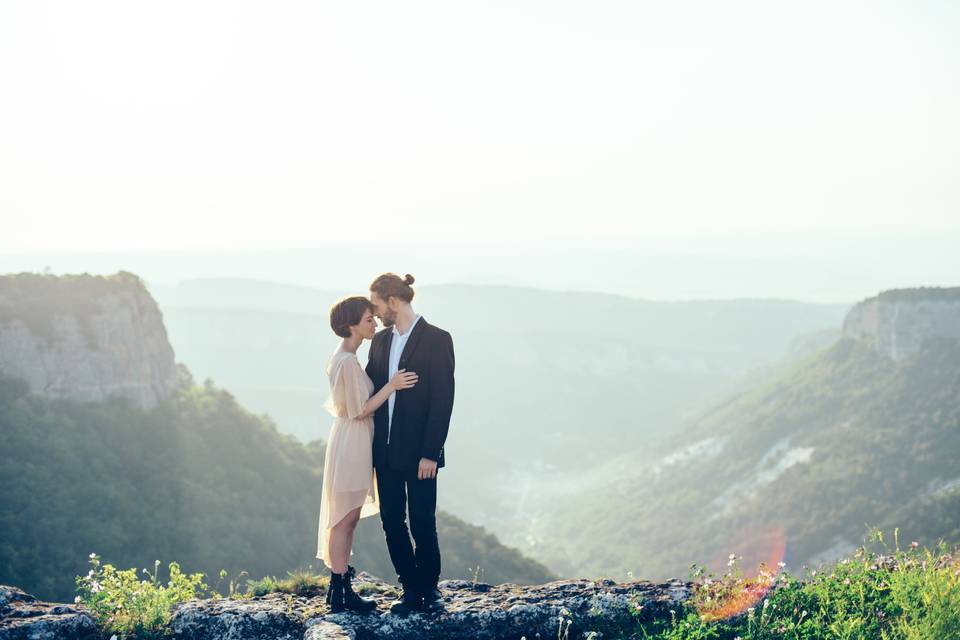 Pedir mano: pareja elegantemente vestida y en actitud cariñosa en una montaña