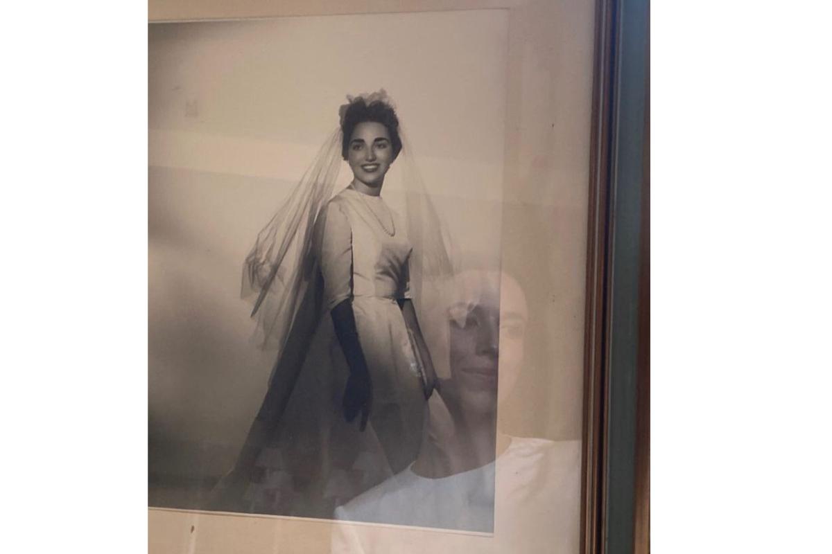foto antigua de una mujer vestida de novia con el reflejo de otra persona