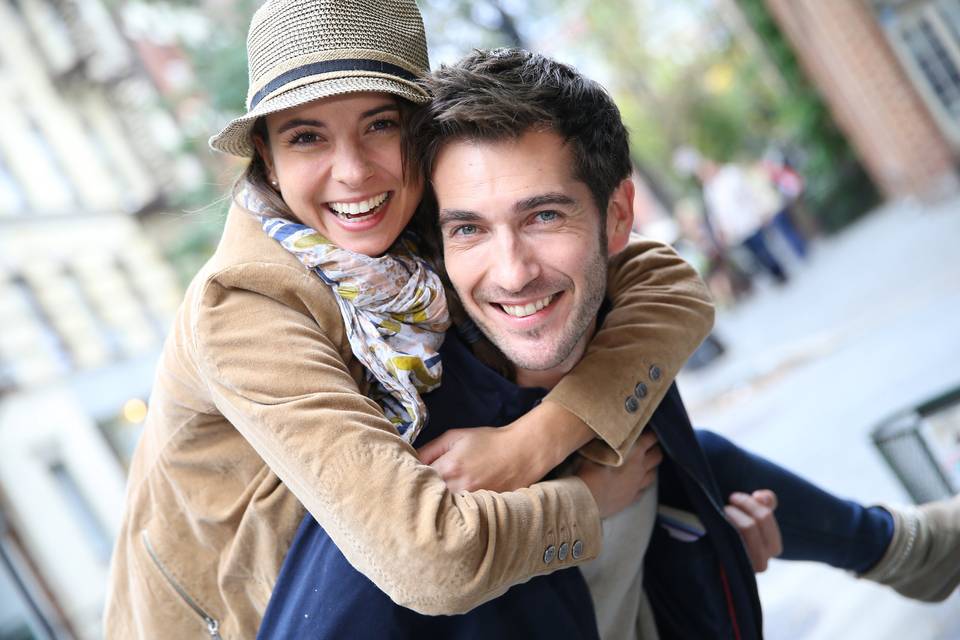 5 años de casados: pareja joven muy sonriente con una chica subida a hombros de un chico