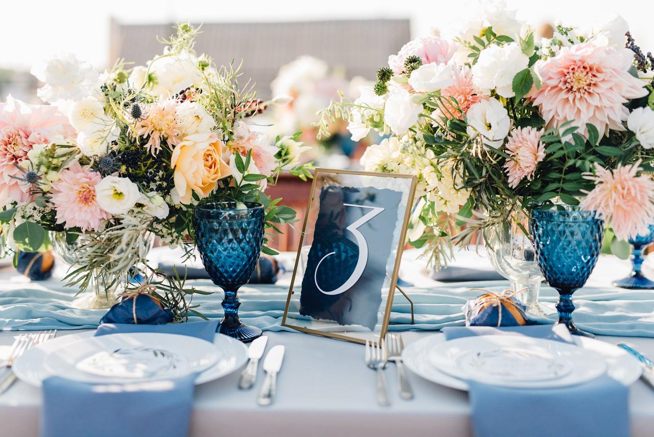Color boda su significado: servilletas, copas y número de mesa en azul