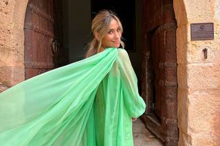 María Pombo posa de espaldas con un vestido verde de gasa con capa ante una puerta