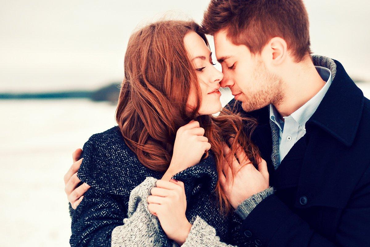 Hablar de relaciones pasadas con tu pareja: pareja abrazada y muy junta mientras se protege del frío exterior