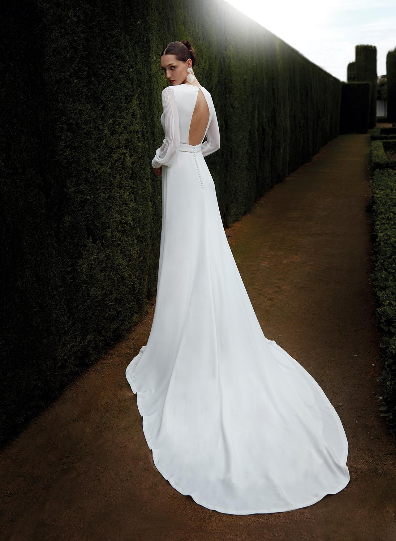 Chica con el pelo recogido con un vestido de novia que deja parcialmente la espalda al descubierto
