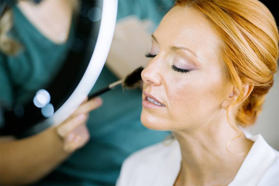 novia con pelo cobrizo en la sesión de maquillaje 