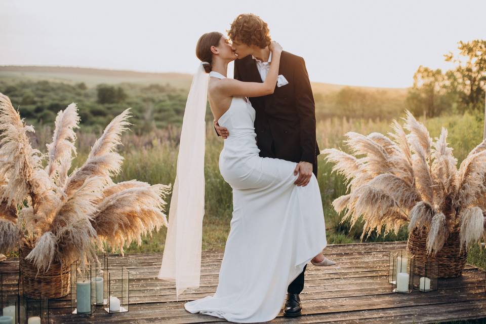 Pareja de recién casados se abraza y besa en el altar de su boda civil al aire libre