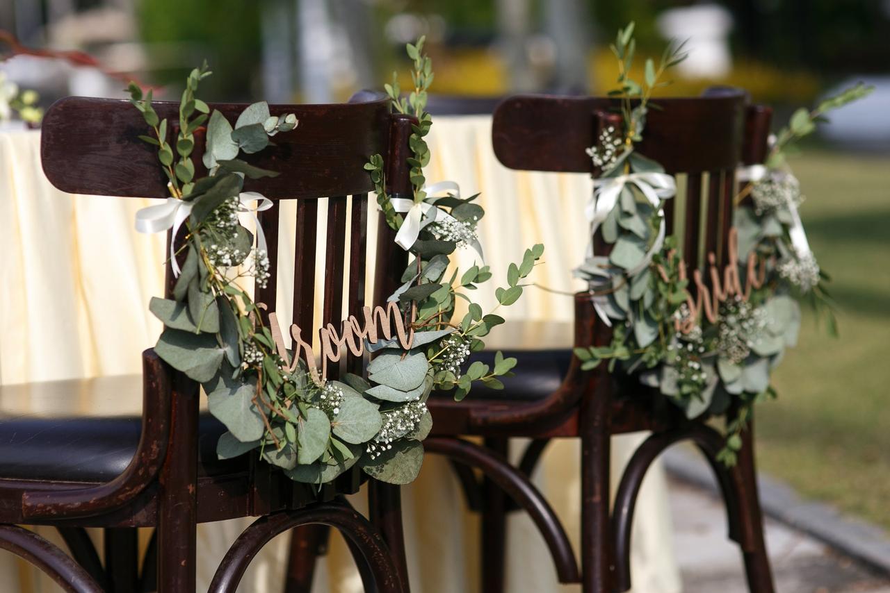 Sillas de los novios el día de la boda con nombres de groom y bride y elementos naturales