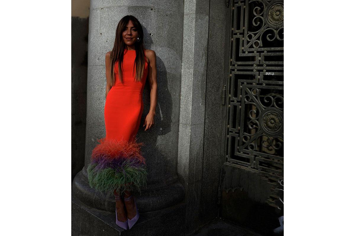 Paula Ordovás con un vestido naranja ceñido con plumas en el bajo de la falda
