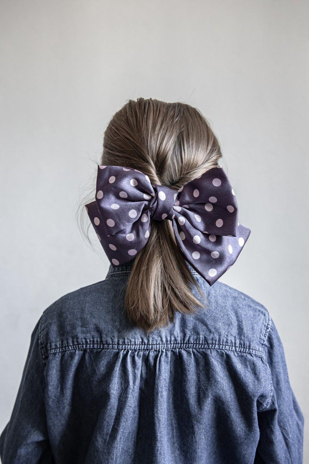 Peinados invitada boda pelo corto: coleta mini decorada con lazo en azul oscuro con lunares blancos