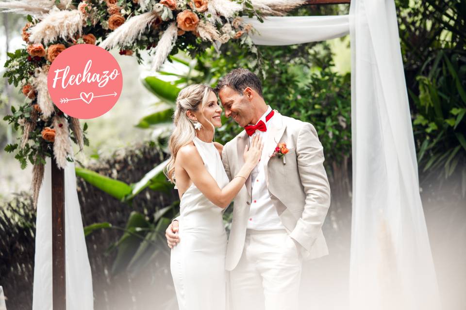 Pareja de recién casados junto al altar de su boda civil al aire libreonia saludan bajo una carpa