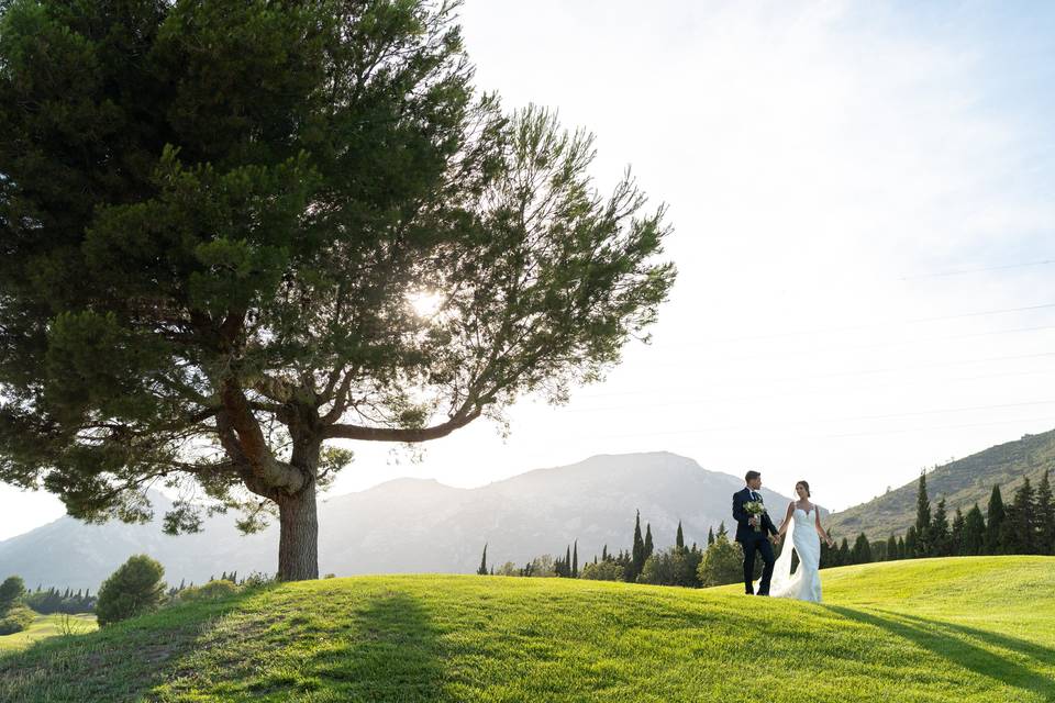 Cómo dar dinero una boda: pareja de recién casados caminan por un jardín con césped cogidos de la mano