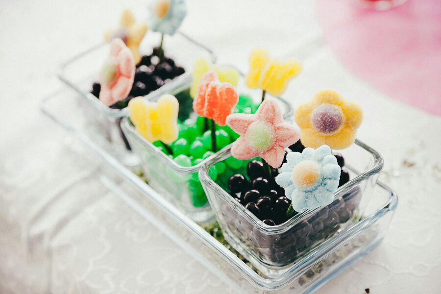 Macetas decorativas llenas de gominolas en la mesa dulce de la boda