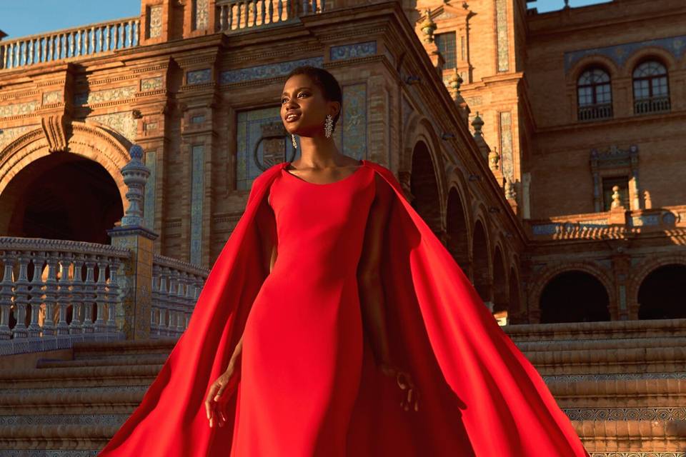 красное праздничное платье Pronovias с облегающим лифом и причудливой накидкой идеально подходит для смелой гостьи на свадьбе