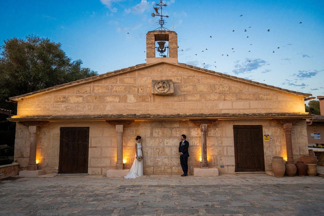 Exterior de una iglesia el día de la boda con los novios frente a ella durante la sesión fotográfica
