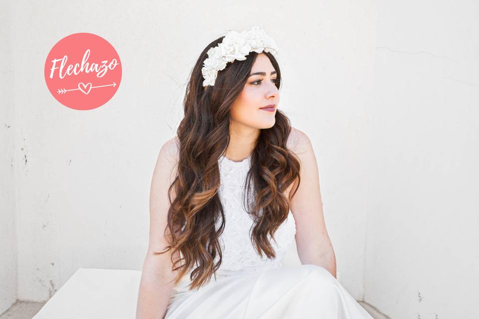 Chica con una melena suelta y ondulada con una diadema de flores blancas