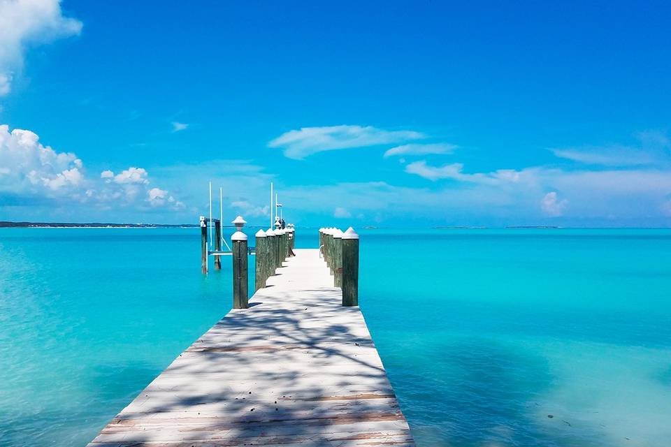 Preciosa vista del océano en un precioso color azul desde un embarcadero de madera en la isla de Exuma, en las Bahamas