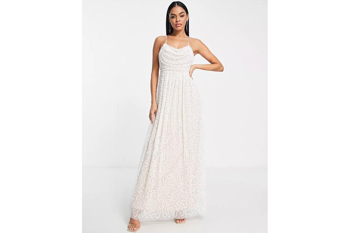 Chica morena con el pelo suelto con un vestido de novia con cuello desbocado y tirantes espagueti