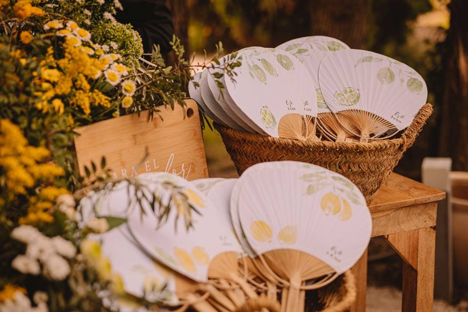 Detalles para los invitados de una boda: rincón con paipáis estampados con variados elementos cítricos para combatir el calor