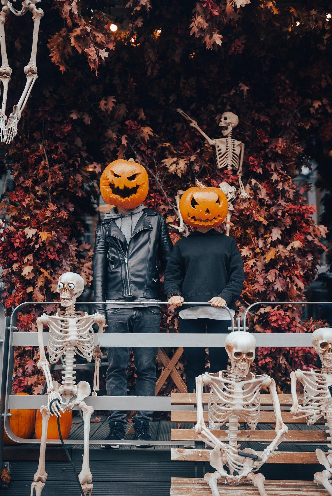 Disfraces Halloween pareja: pareja con ropa informal con dos máscaras de calabazas asesinas