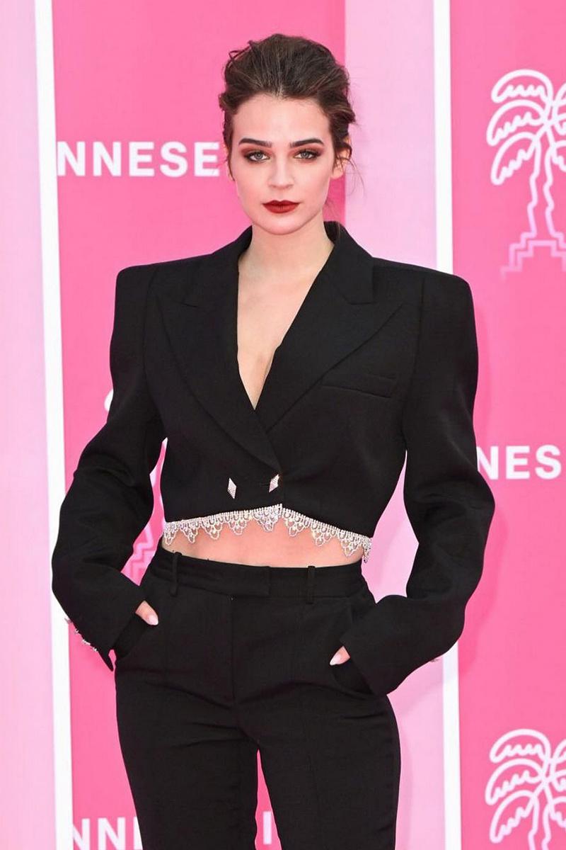Laura Escanes con traje de chaqueta cropped con hombreras y pantalón de sastre total black
