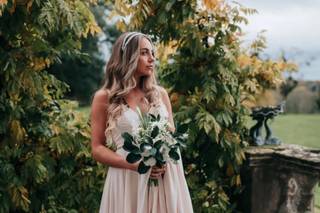 Novia el día de su boda con el ramo de novia en la mano y una bonita diadema de novia en la cabeza