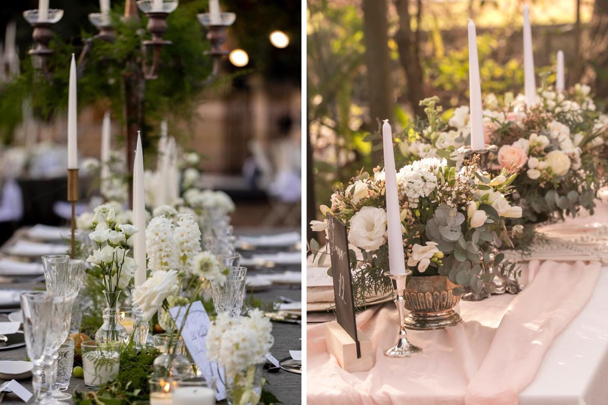 mesa decorada con velas clásicas y flores blancas con algunas hojas verdes