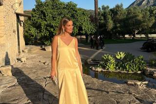 Chica sonriente con un vestido amarillo y un bolso de mano cuadrado