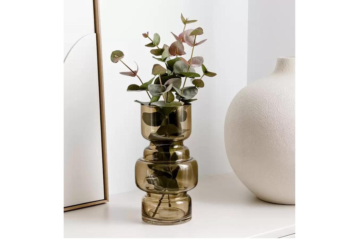 Jarrón transparente de cristal beige con ramas de eucalipto