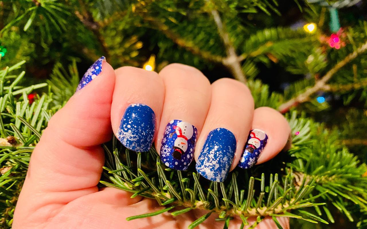 Uñas navideñas 2024 elegantes en azul y plata con algunas uñas con muñecos de nieve pintados