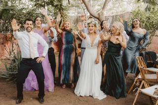 Pareja de novios baila una coreografía con los invitados de su boda en medio del campo