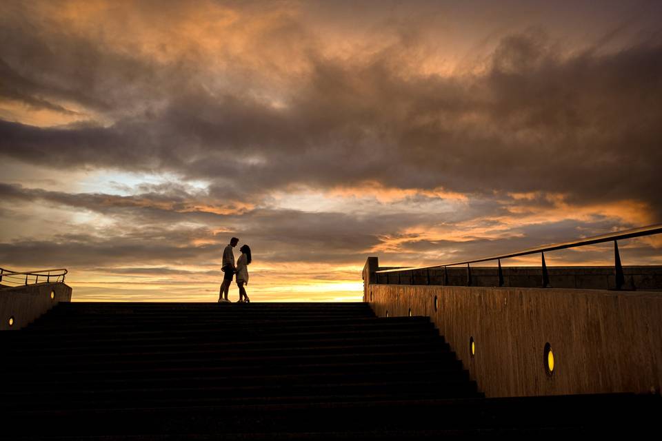 Regalo de boda para el novio: chico y chica cogidos de la mano durante la puesta de sol