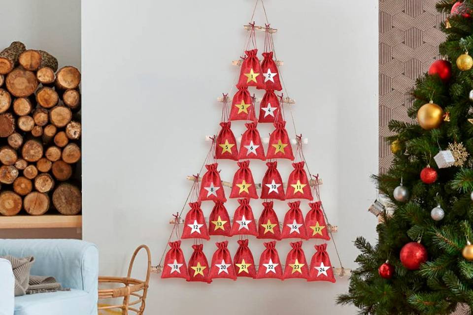 Calendario de Adviento con forma de árbol de Navidad y suspendido, con 24 saquitos de color rojo con los números de todos los días
