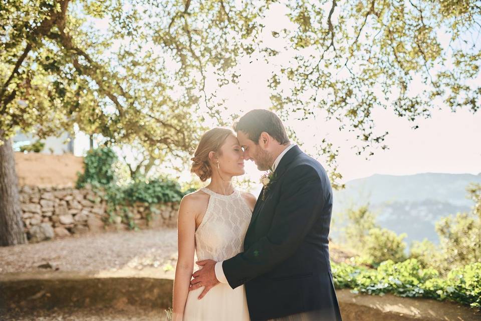 Chico y chica vestidos de novios en una pose muy romántica en un bonito espacio al aire libre