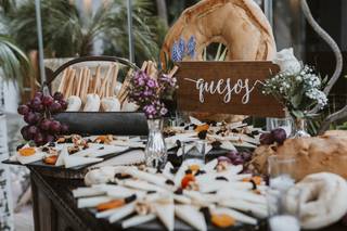 Mesa de quesos boda: cómoda de madera con bases de pizarra y todo tipo de quesos ya cortados acompañados de quesos y frutos secos