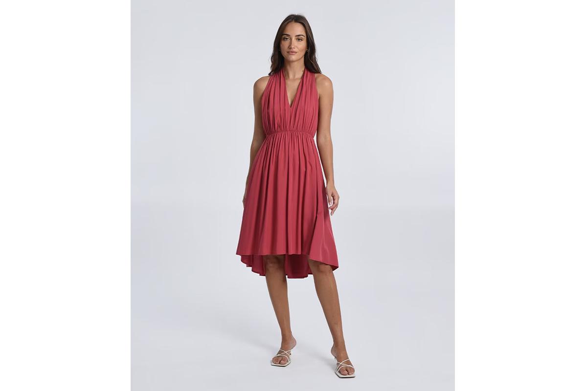 Chica morena con el pelo suelto con un vestido midi de bajo asimétrico en color coral