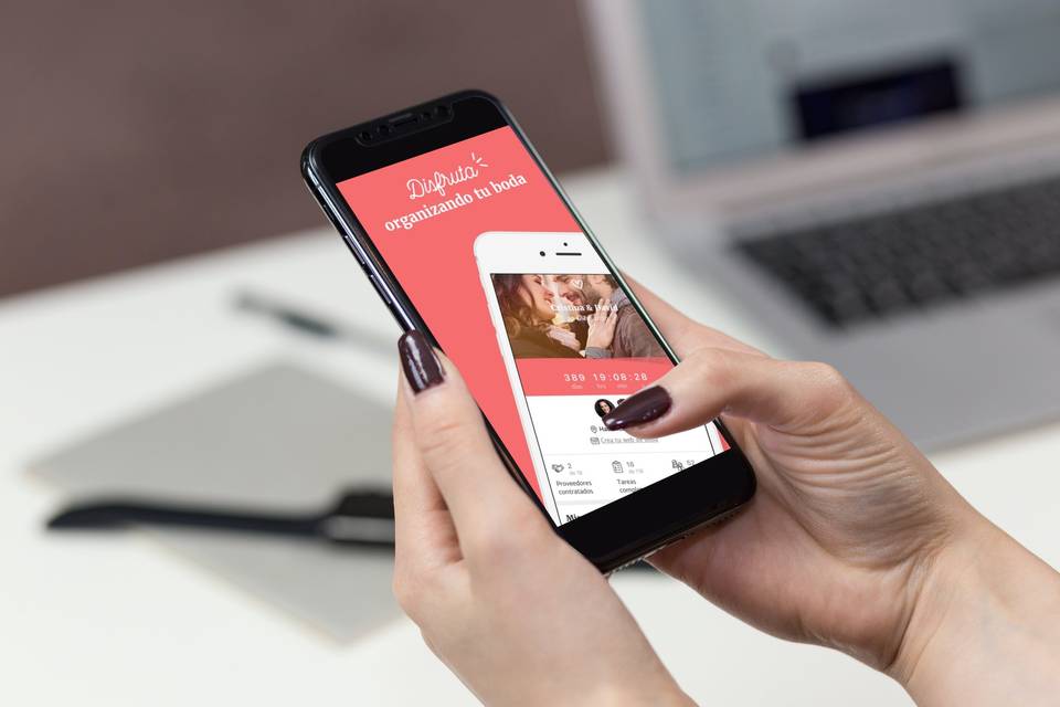 primer plano de unas manos de mujer sujetando un móvil con la app de Bodas.net abierta, ideal para organizar la boda