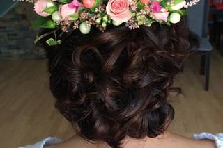 Peinados invitada boda pelo rizado: trenza en pelo moreno rizado con tocado de fllores