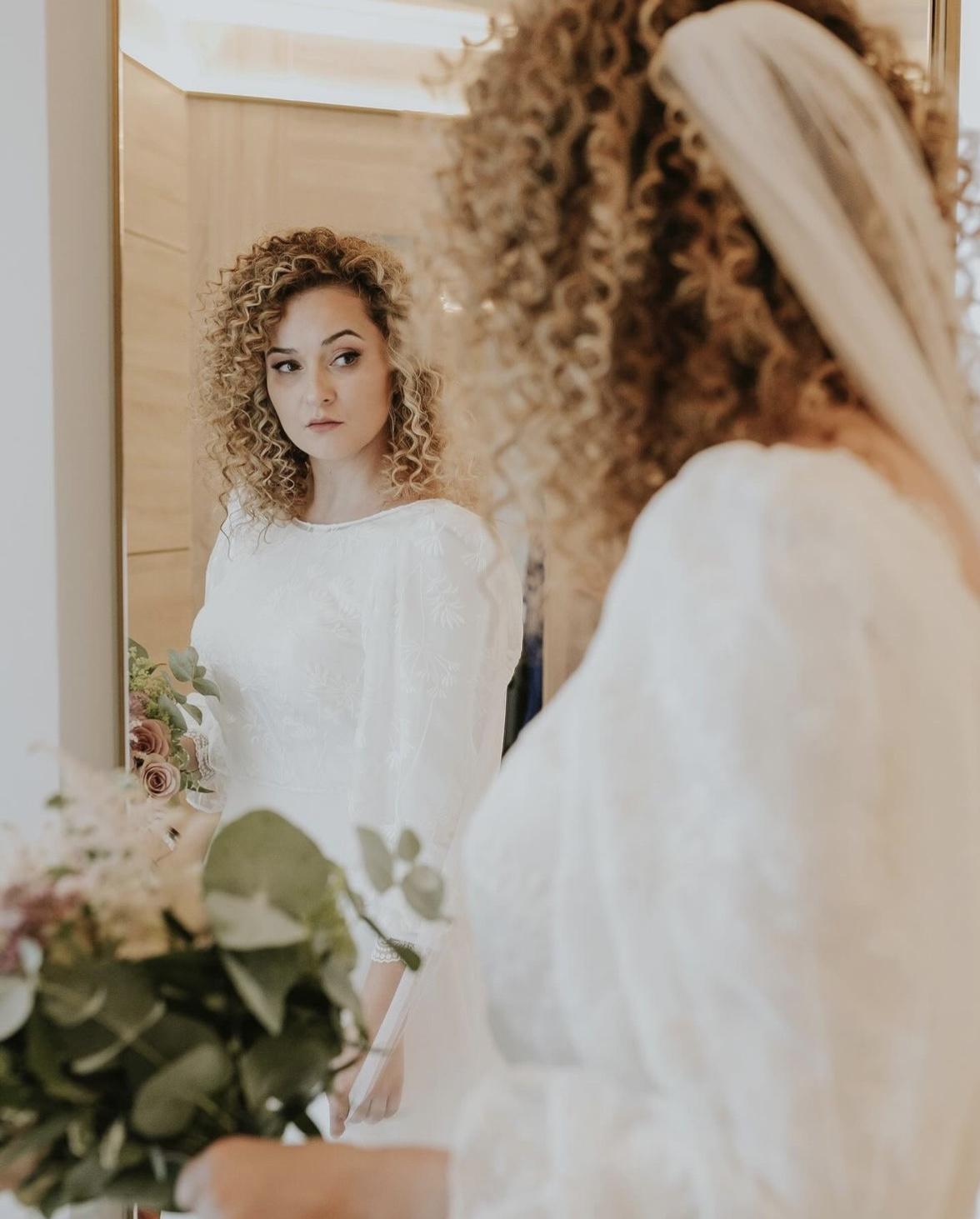 Peinados invitada boda pelo rizado: trenza en pelo rubio rizado con velo