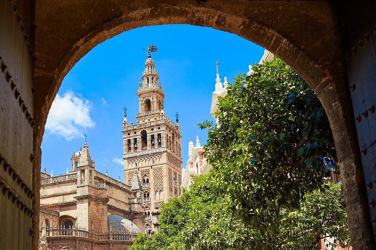 Torre de La Giralda de Sevilla vista a través de una puerta de madera