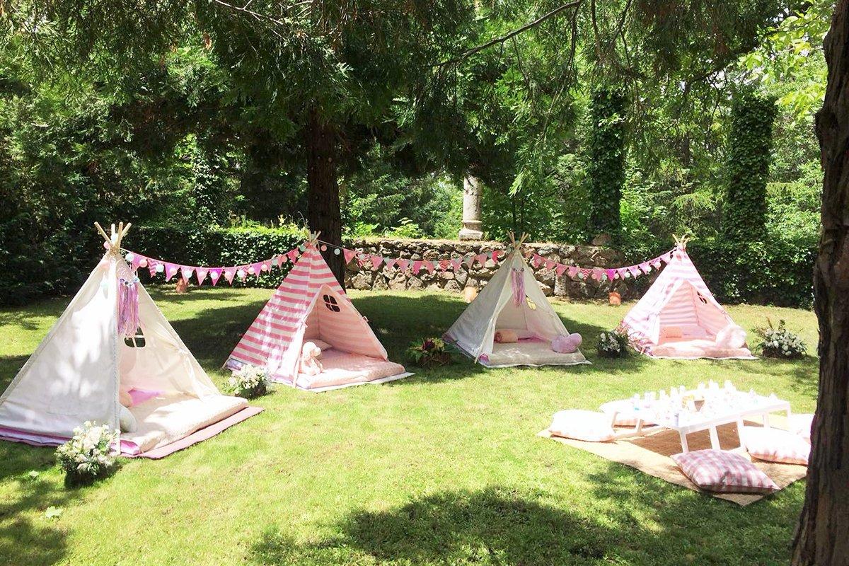 Tipis infantiles de color rosa en un jardín con césped para los niños de una boda