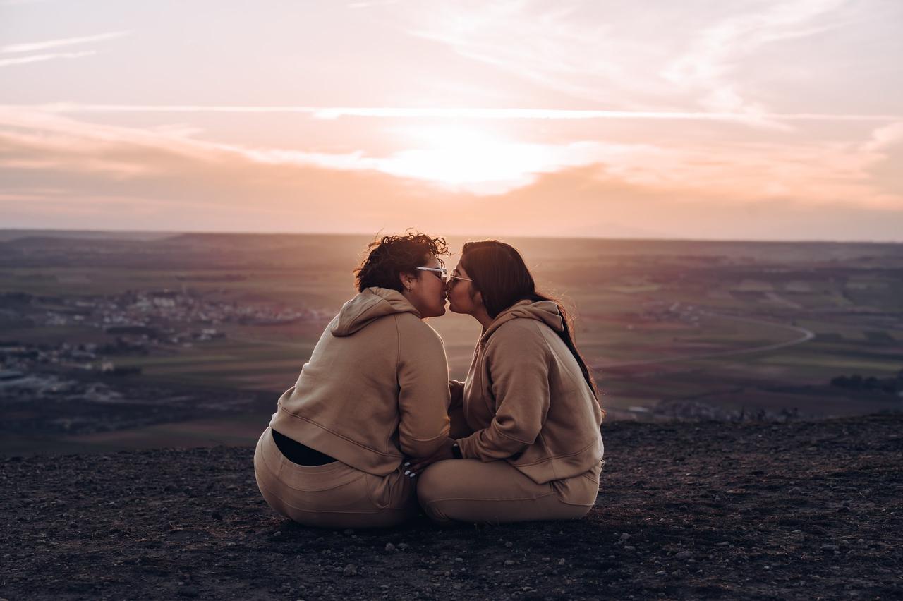 Pareja de mujeres besándose al atarceder, por Zoraida Photography