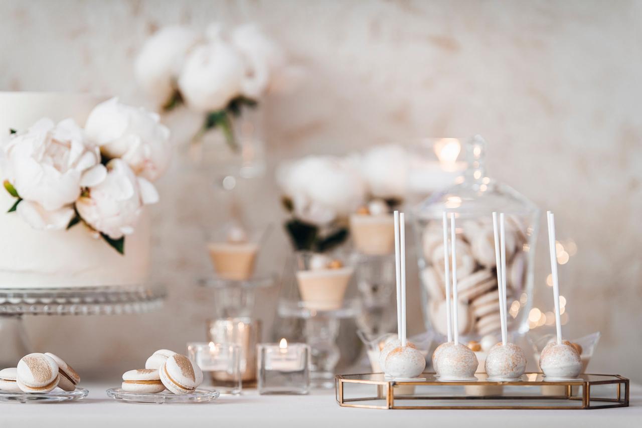 Color boda su significado: mesa de candy bar con dulces y elementos decorativos en blanco