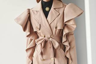 Chaqueta invitada boda otoño: gabardina beige con cinturón de anudar y volantes