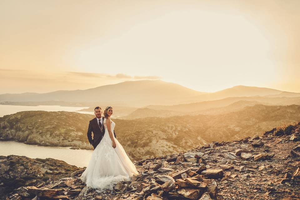 Preguntas fotógrafo boda: chico y chica vestidos de novios posan en un espacio natural durante una puesta de sol