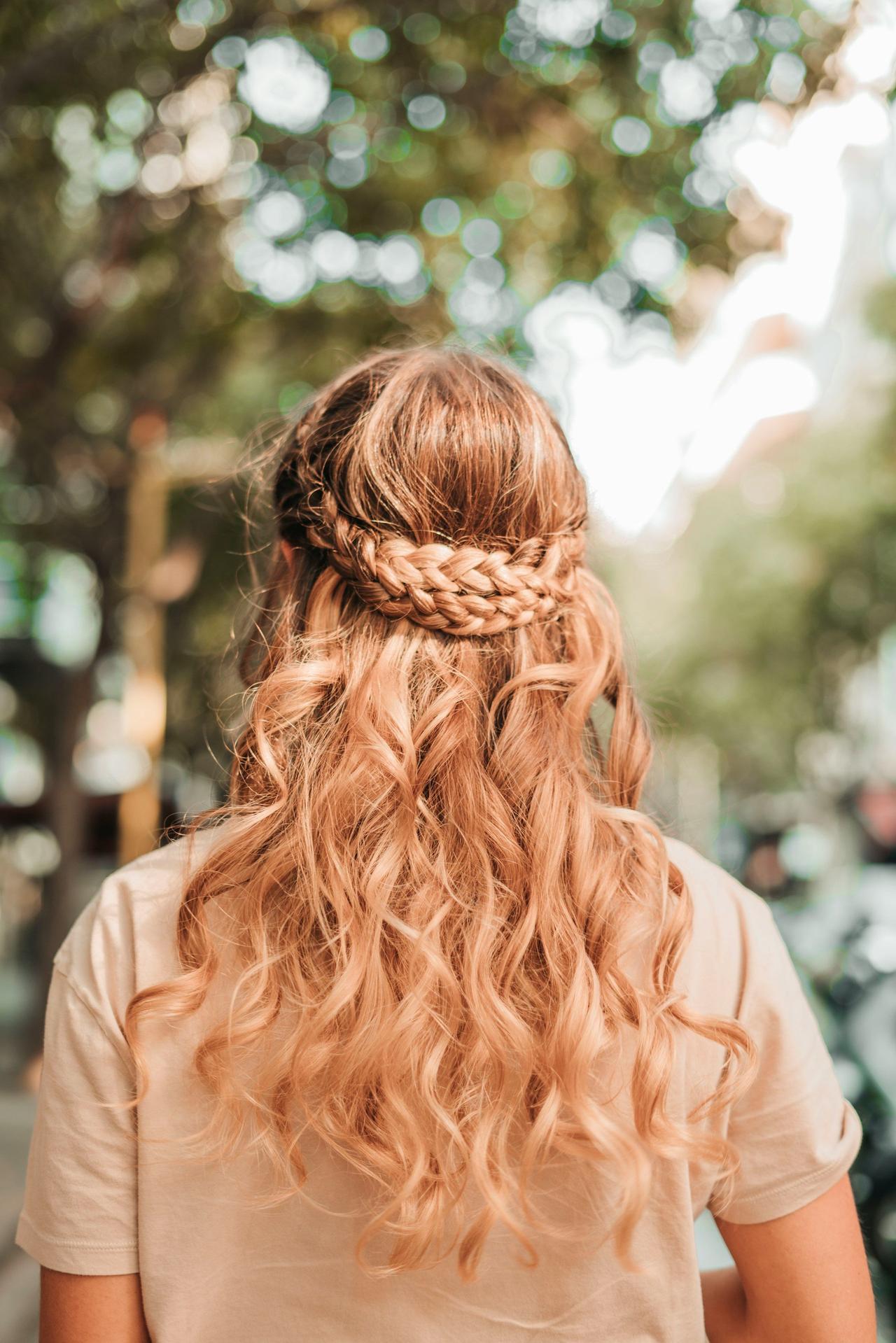 peinados trenzas boda: mujer pelirroja de espaldas con semirrecogido con ondas y trenzas