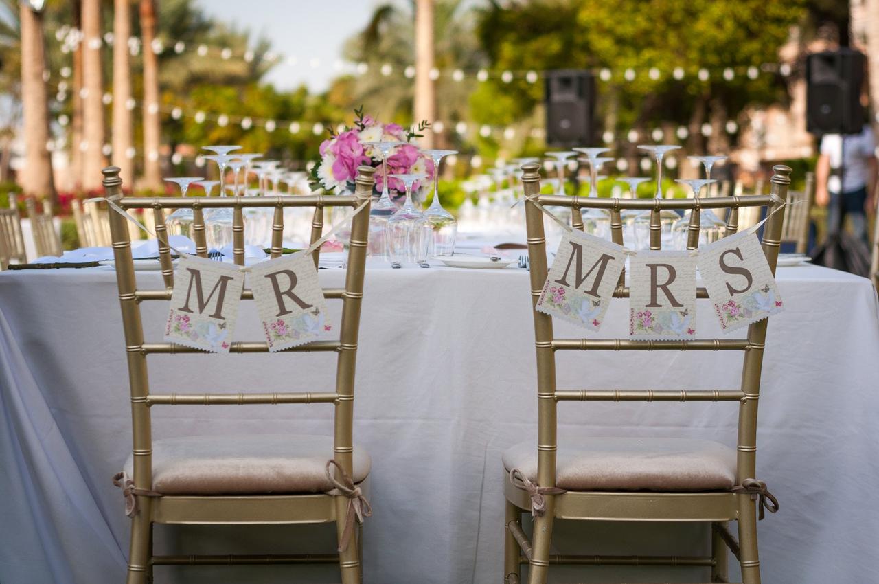 Sillas de los novios el día de la boda con banderines de Mr. y Mrs.