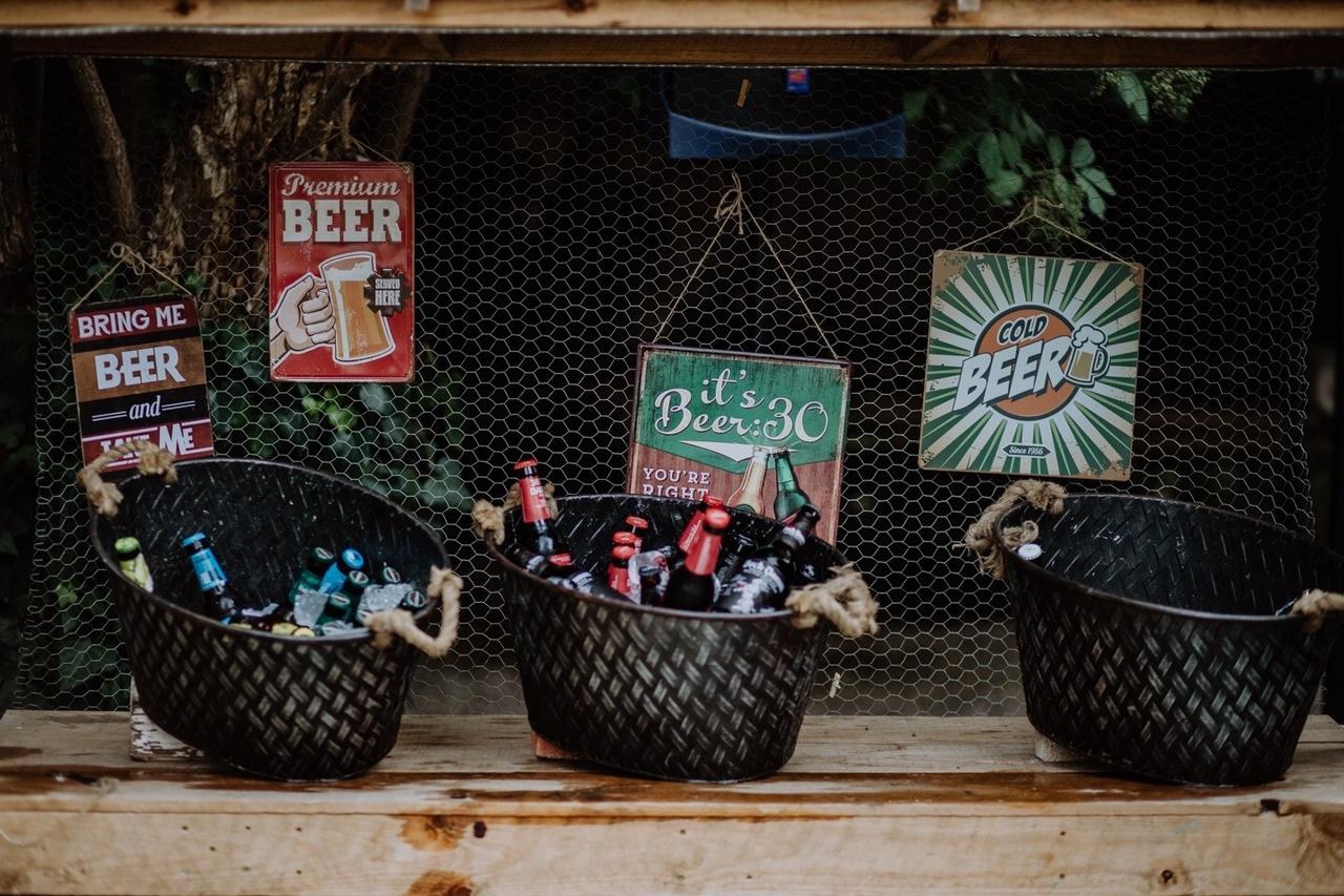 Cerveza para bodas: cestos con diferentes tipos de cervezas con carteles colgando