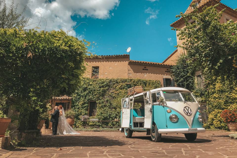 Furgoneta Wolkswagen de aire retro en blanco y azul claro aparcada en el patio de una casa