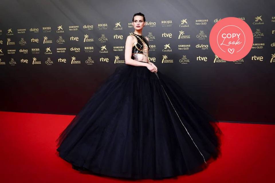 Alfombra roja de los Premios Goya 2022: Milena Smit con un conjunto de dos piezas formado por top corto con detalles dorados y falda de seda en color negro